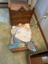 wooden doll bed with doll.