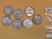 Seven mixed silver half dollars