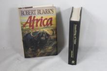 Two hard cover books. Something of Value, used and Africa, like new.