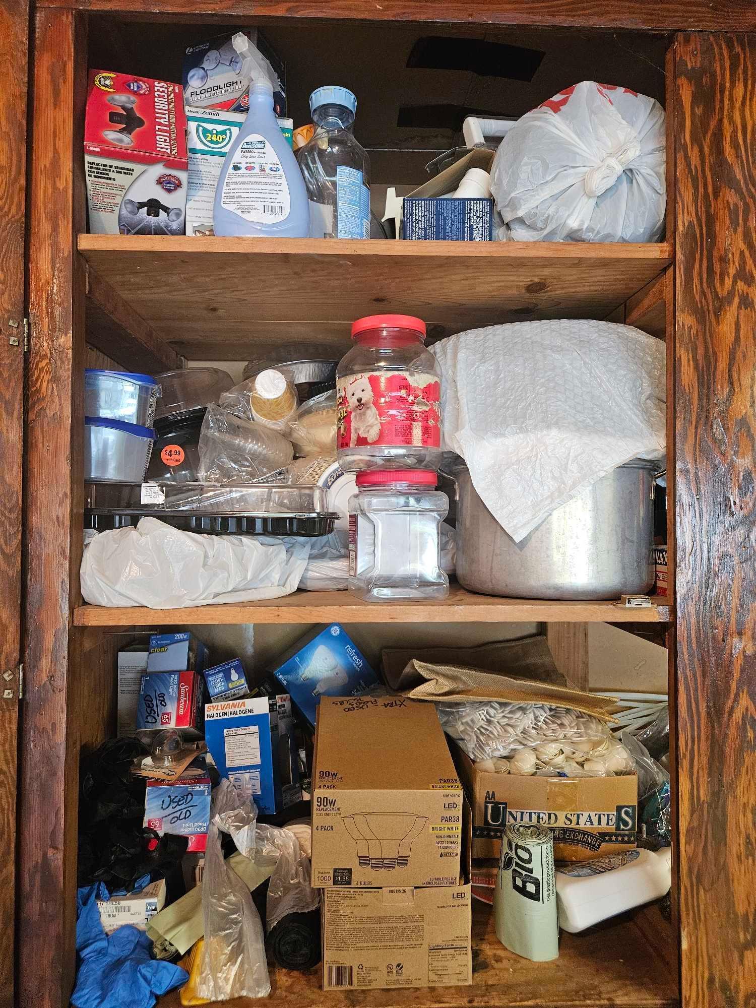 Cabinet contents including banners and vacuum cleaner on floor.