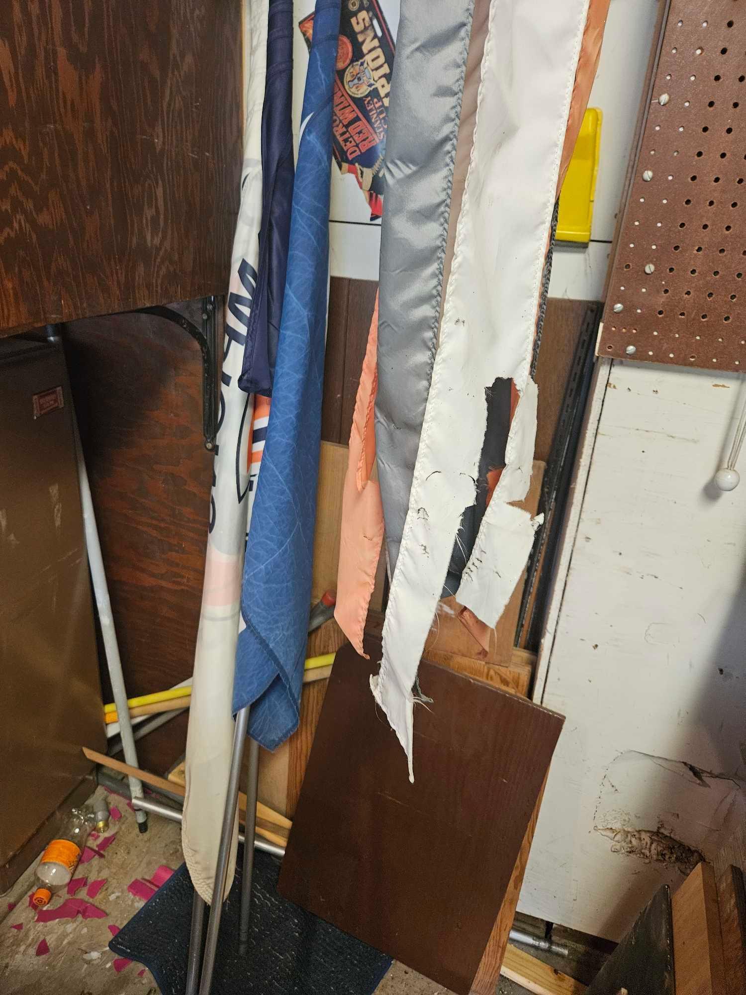 Cabinet contents including banners and vacuum cleaner on floor.