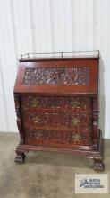 Antique ornate carved mahogany slant front desk with lion head motif and claw feet...and wheels.
