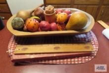 Red check placemats, wood bowl with fruit.
