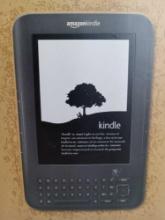 Amazon Kindle with charging cord in box.
