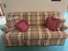 Plaid three cushion sofa and tan fireplace chair